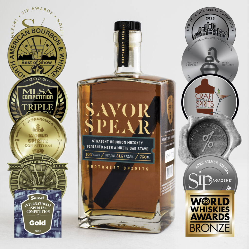 A bottle of Savor Spear Bourbon sitting on a white backdrop. There are 12 icons on the photo next to the bottle that represent all of the awards the whiskey has won.