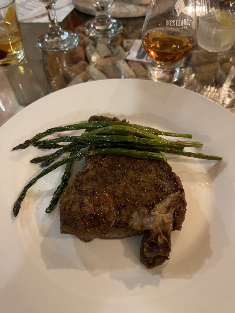 Image of a nice looking ribeye steak topped with roasted asparagus