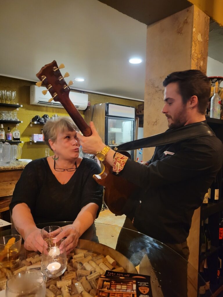 A guitarist serenades a woman at her table